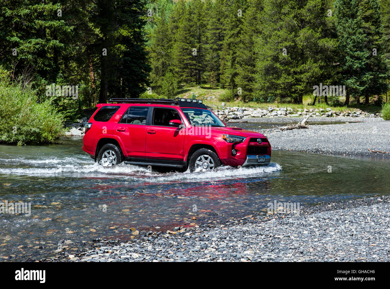 Red 2014 Toyota 4Runner Trail Premium on rough four wheel drive 4WD road, crossing Slate River, Crested Butte, Colorado, USA Stock Photo