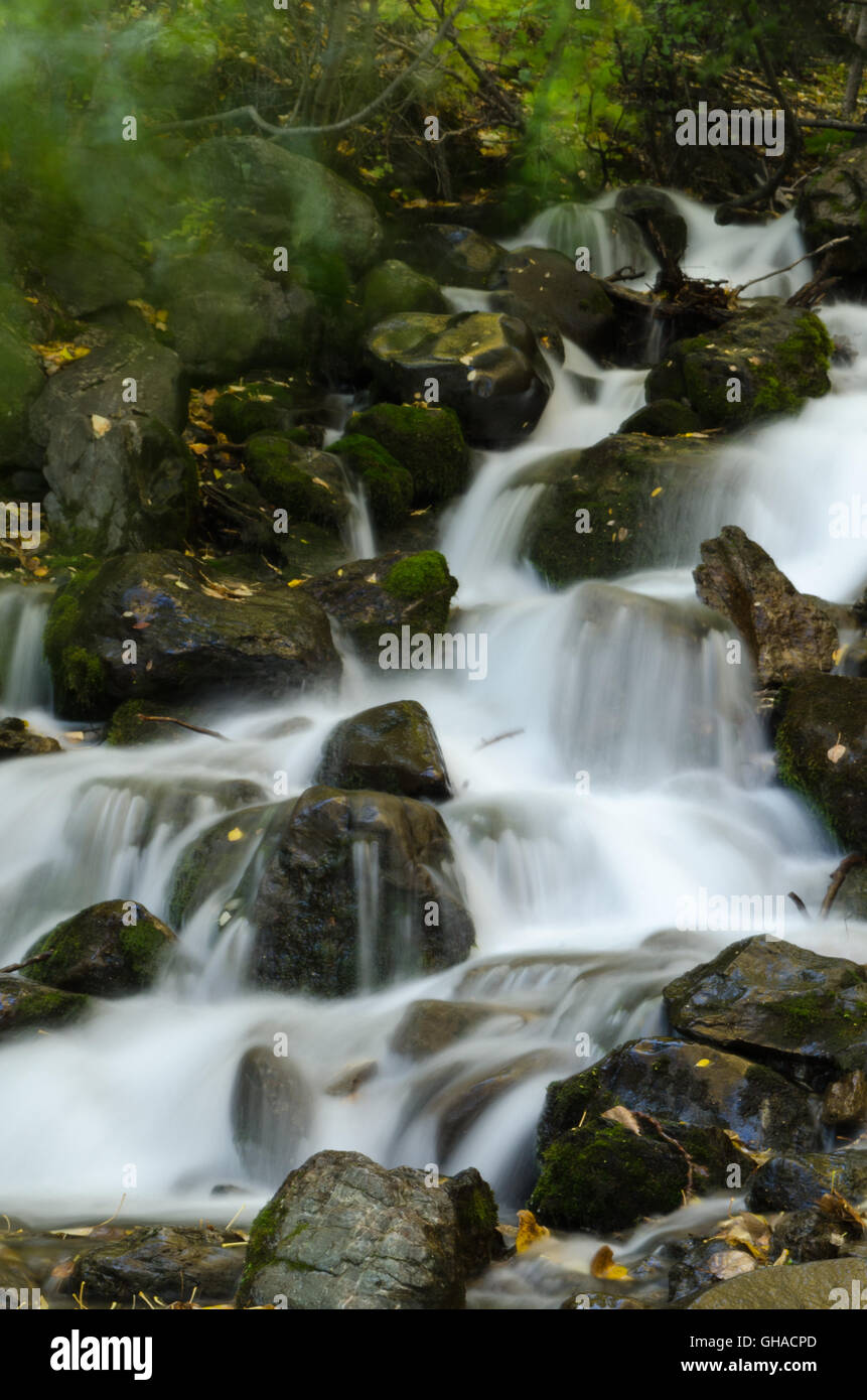Water flows like mist downhill over rocks Stock Photo