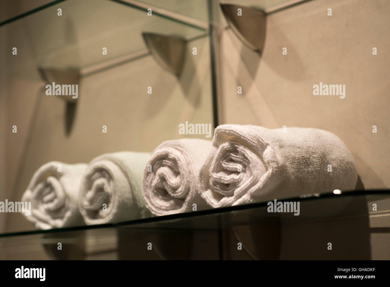 batch towels on glass shelf with mirror reflection Stock Photo