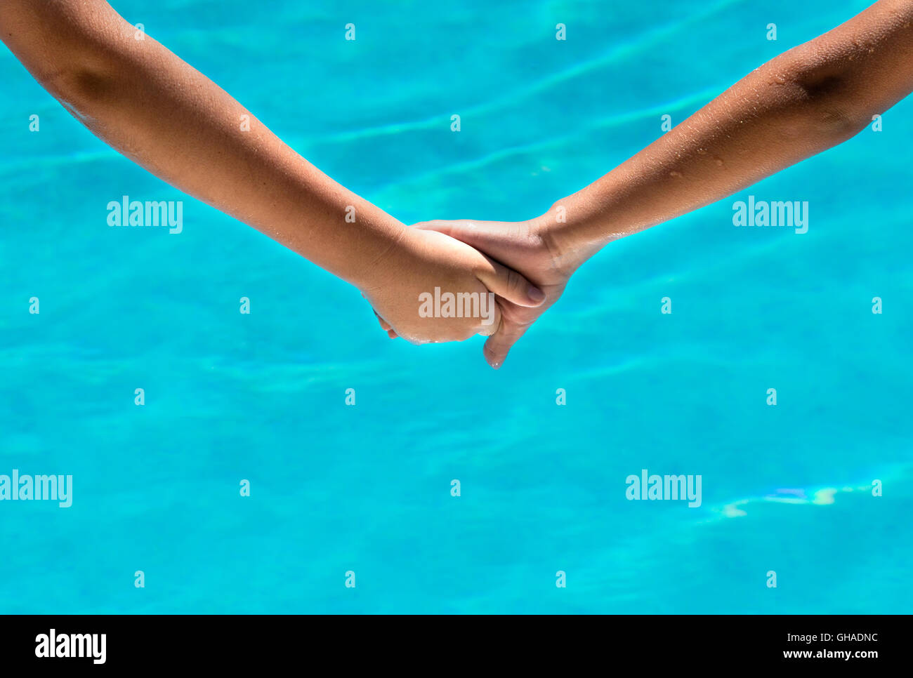 two sun tanned young people holding hands at a holiday vacation  room for text and copy space Stock Photo