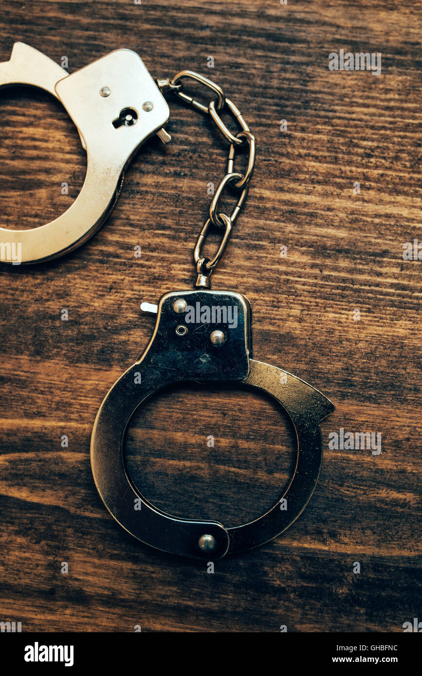 Police handcuffs on investigator detective's work desk, concept of law and crime. Stock Photo