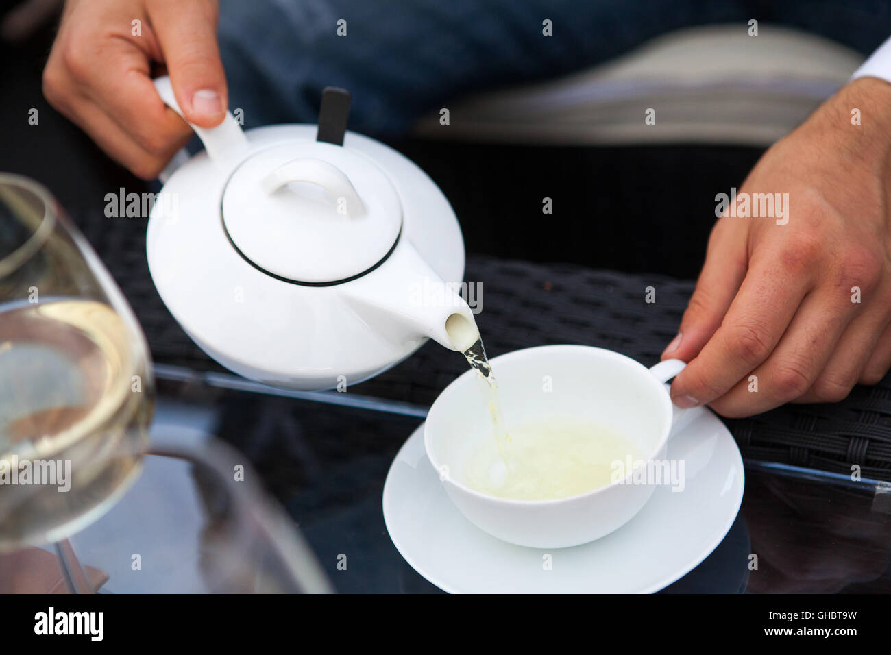 man pours tea from a teapot into a cup Stock Photo Alamy