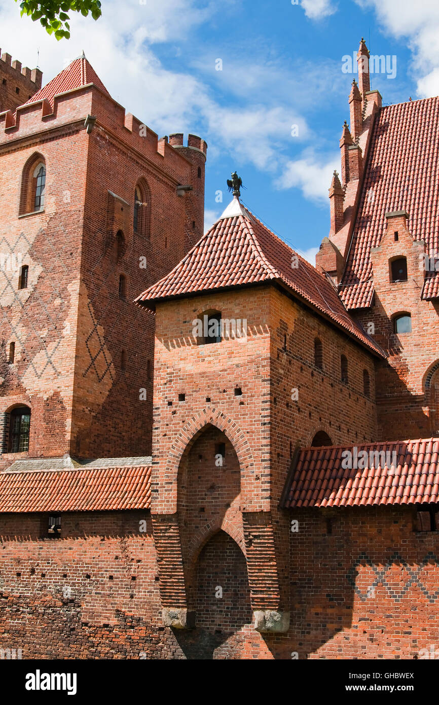 One of the towers of the largest brick castle (Malbork) with a metal statue filinayu Poland Stock Photo