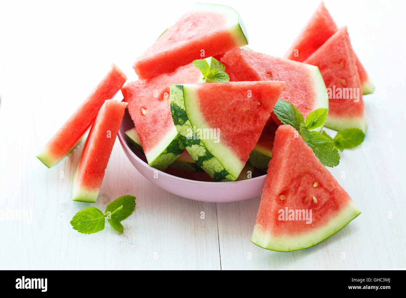 Triangular slices of fresh watermelon with mint on white wooden background Stock Photo