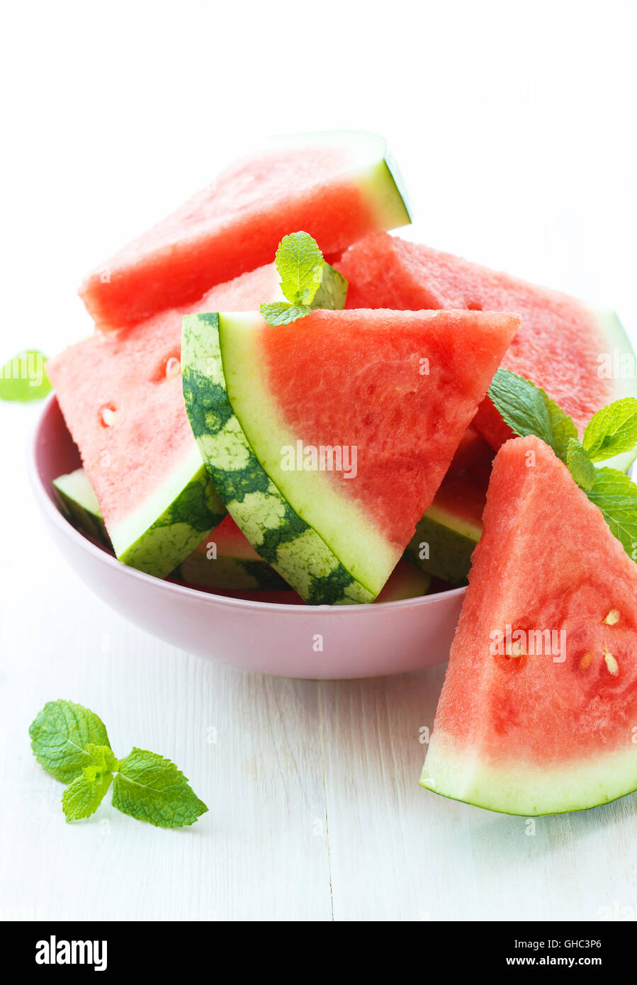 Triangular slices of fresh watermelon with mint on white wooden background Stock Photo