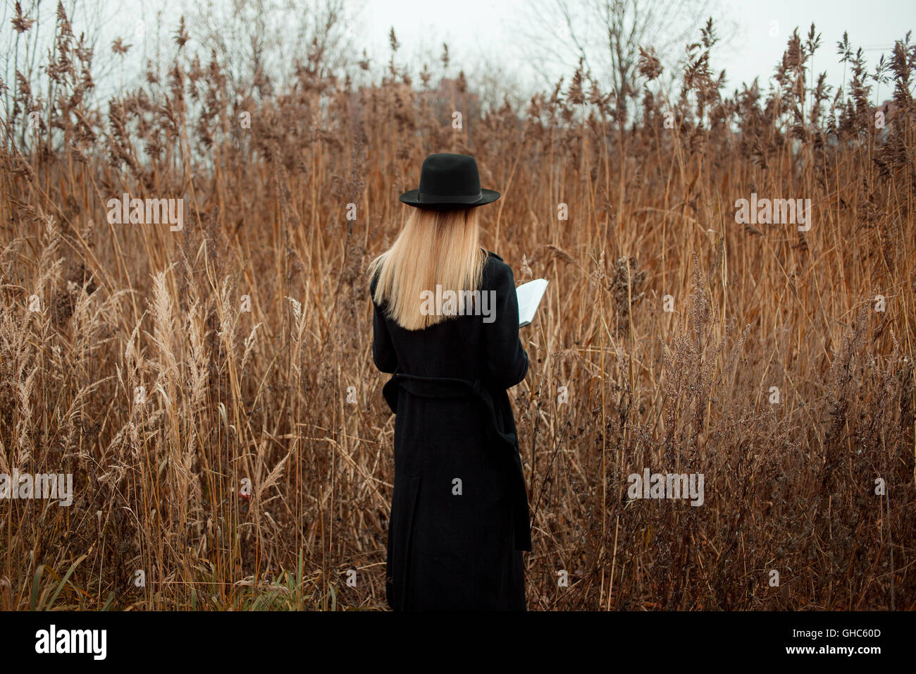 Portrait of young attractive woman in a black coat and hat. She's one ...