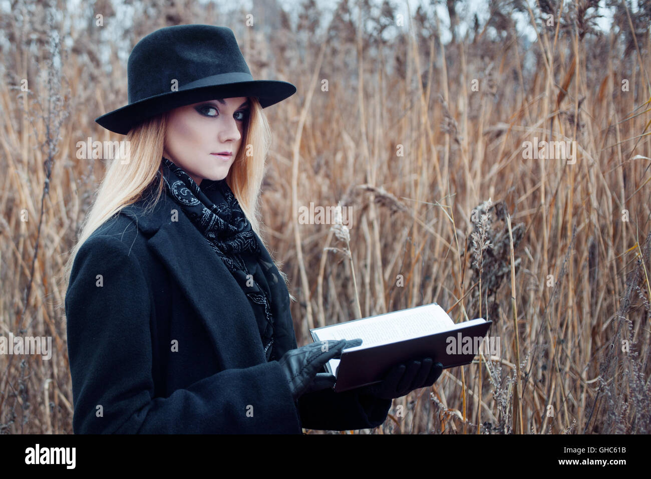 Portrait of young attractive woman in a black coat and hat. She's one ...