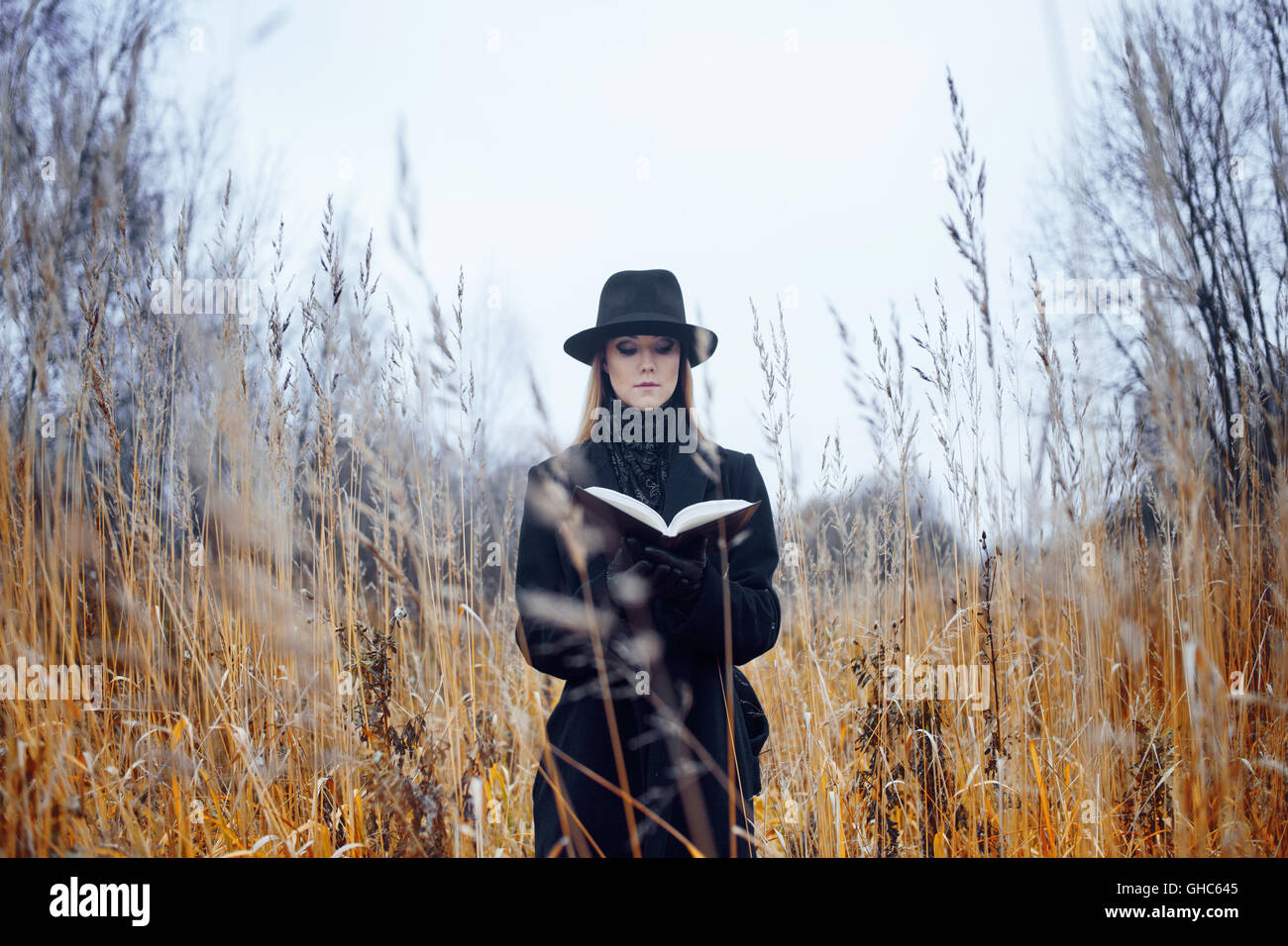 Portrait of young attractive woman in a black coat and hat. She's one ...