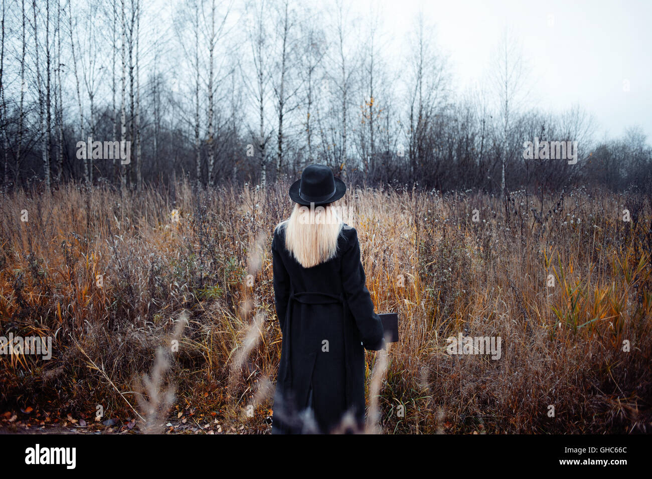 Portrait of young attractive woman in a black coat and hat. She's one ...