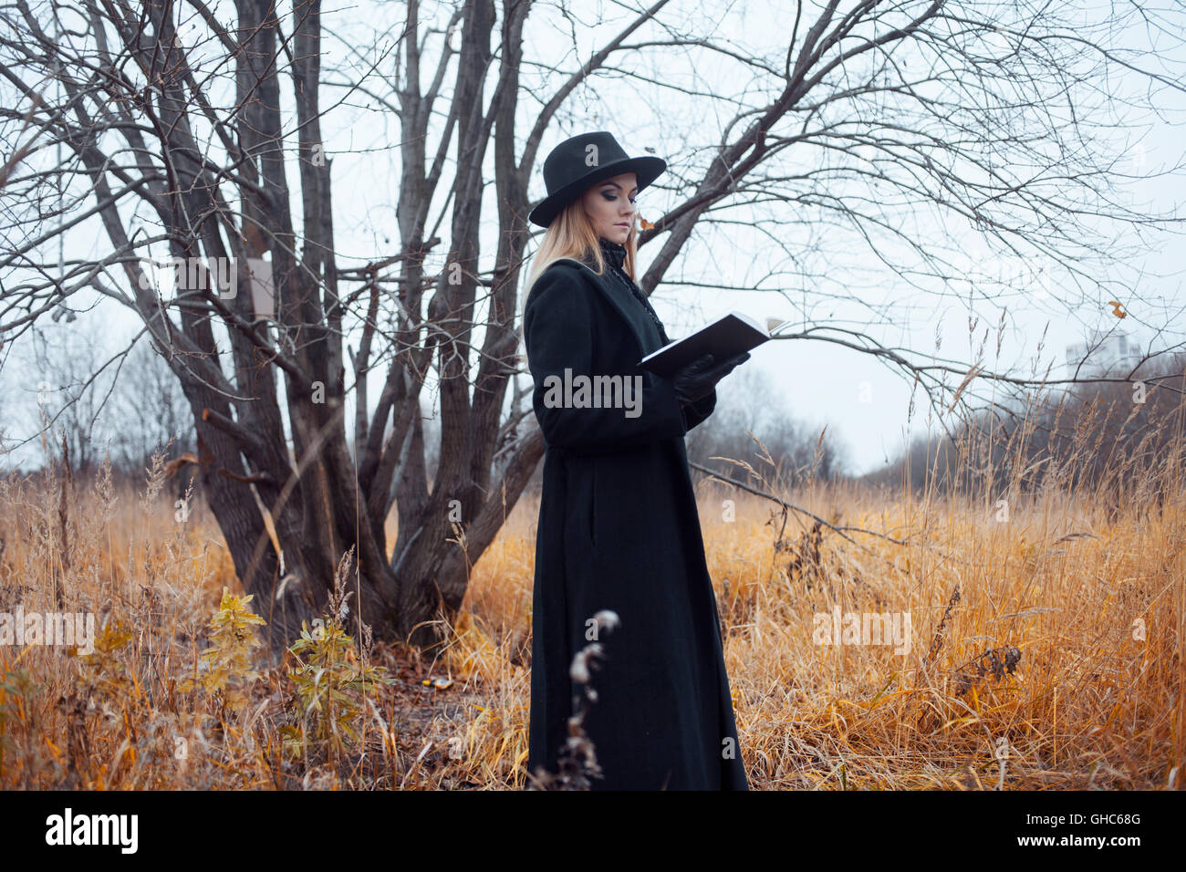 Portrait of young attractive woman in a black coat and hat. She's one ...