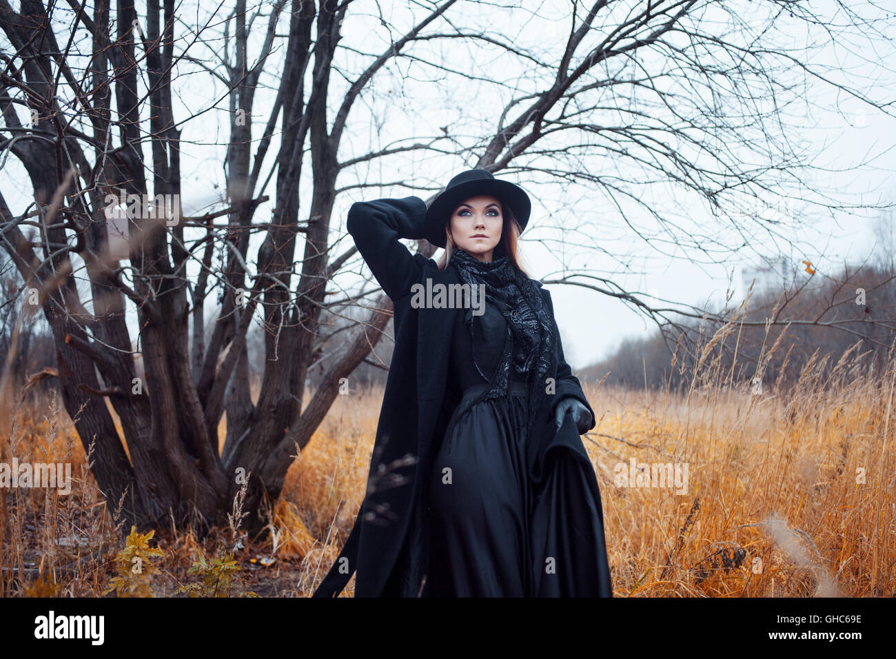 Portrait of young attractive woman in a black coat and hat. She's one ...