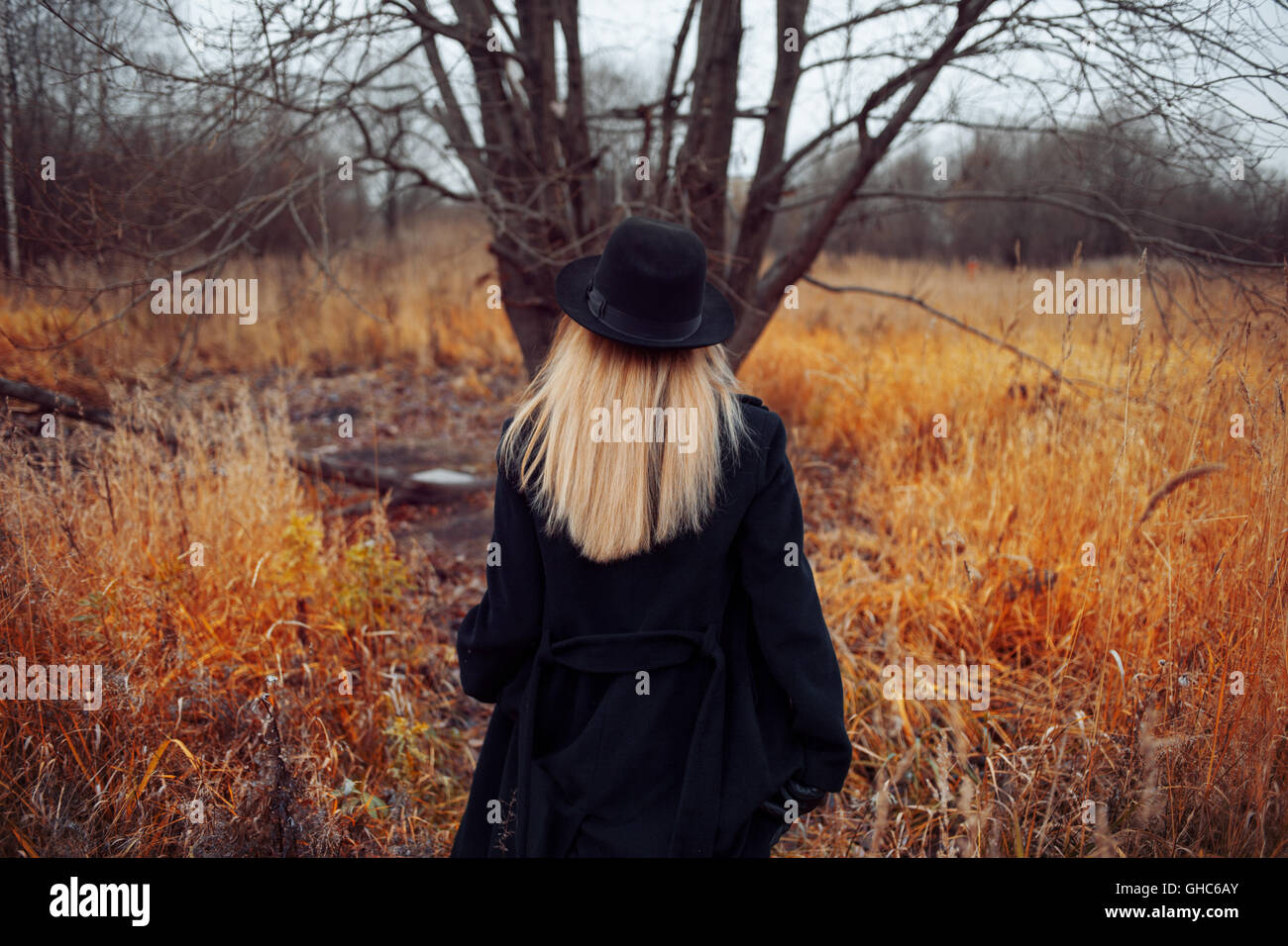 Portrait of young attractive woman in a black coat and hat. She's one ...