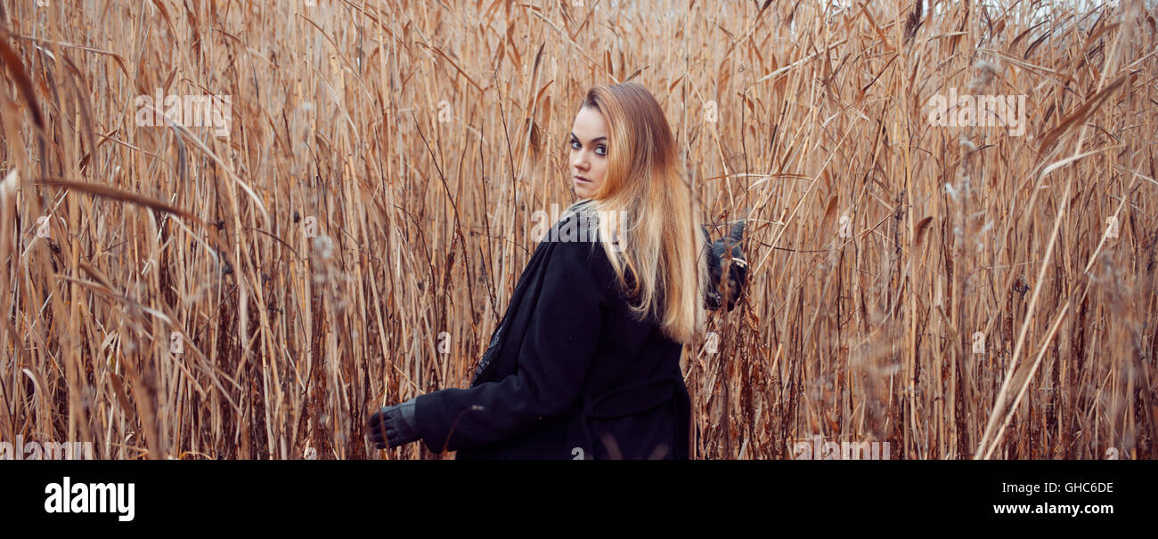 Portrait of young attractive woman in a black coat and hat. She's one ...