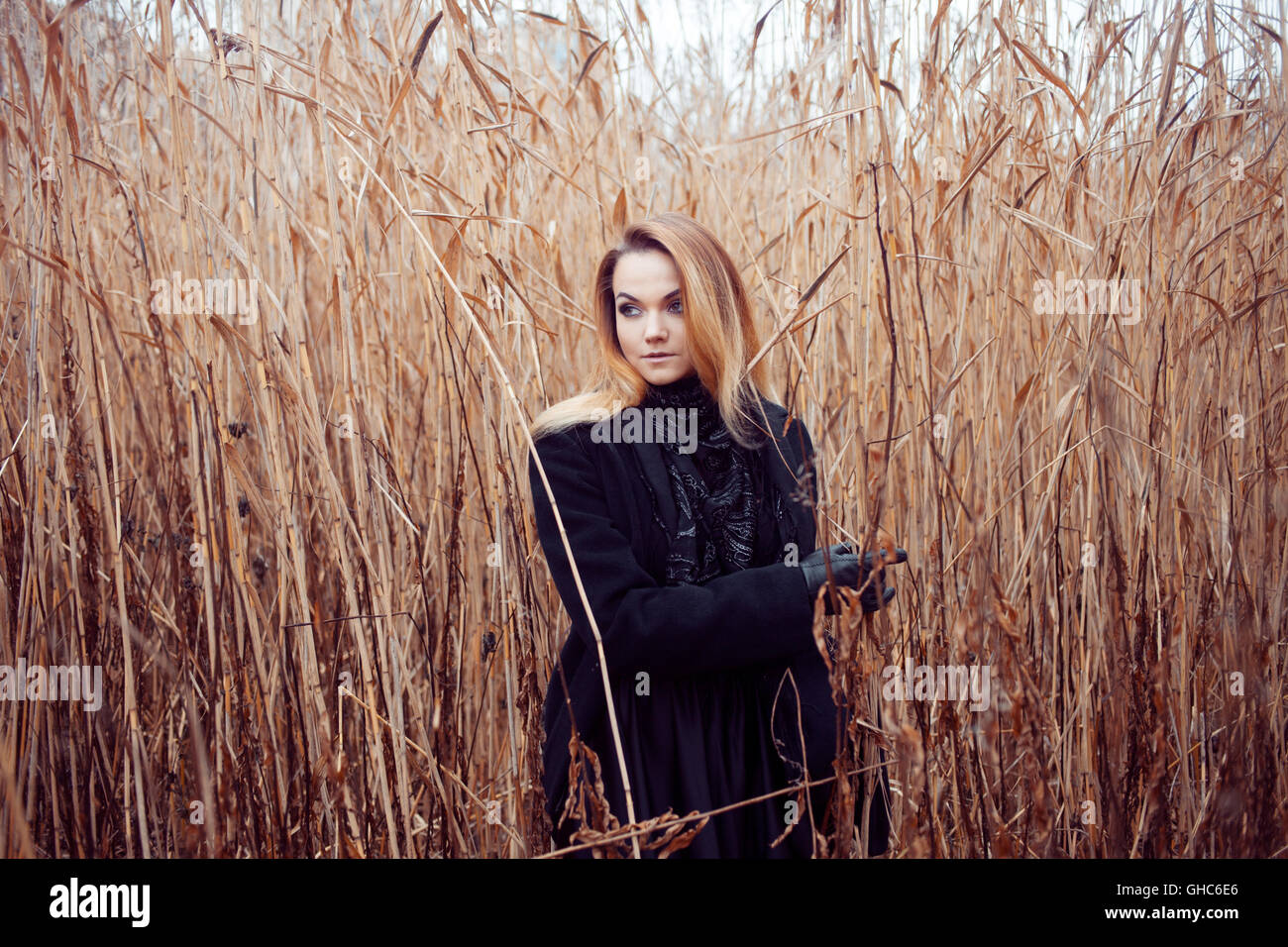 Portrait of young attractive woman in a black coat and hat. She's one ...