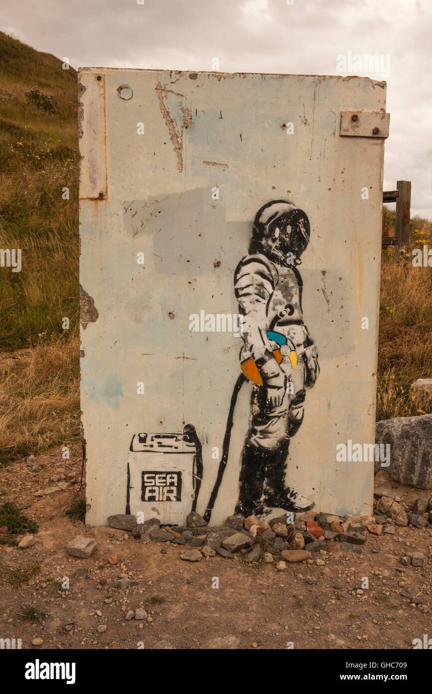 Wall art picture of deep sea diver holding a beach ball and hooked up to 'sea air' container at Skinningrove,North Yorkshire Stock Photo
