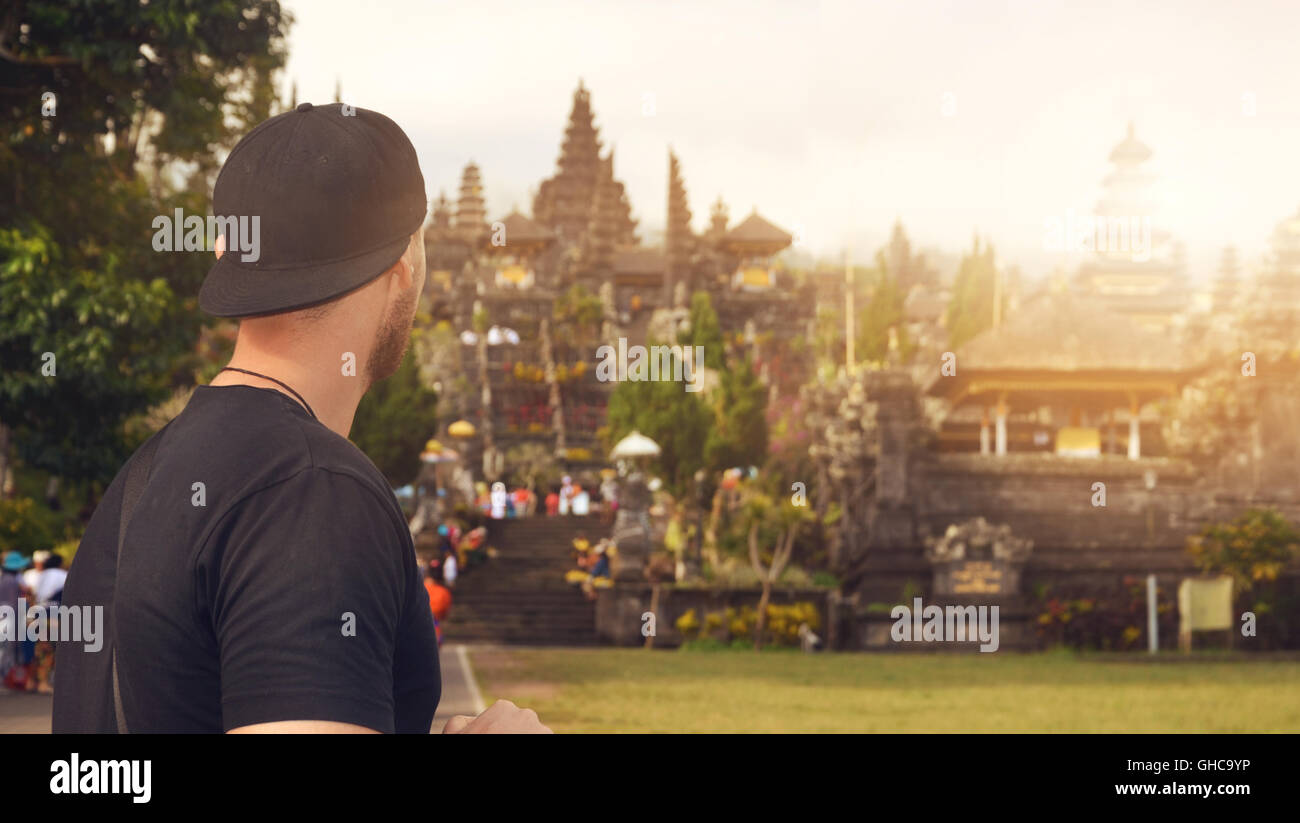 Young backpacker tourist on Bali visits a Hindu temple on a volcano mountain - mother temple Besakih Stock Photo