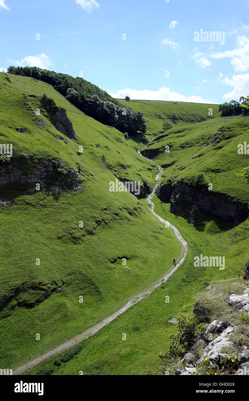 Walkers on the Limestone Way through Cave Dale near Castleton in the Derbyshire Peak District, England, UK Stock Photo