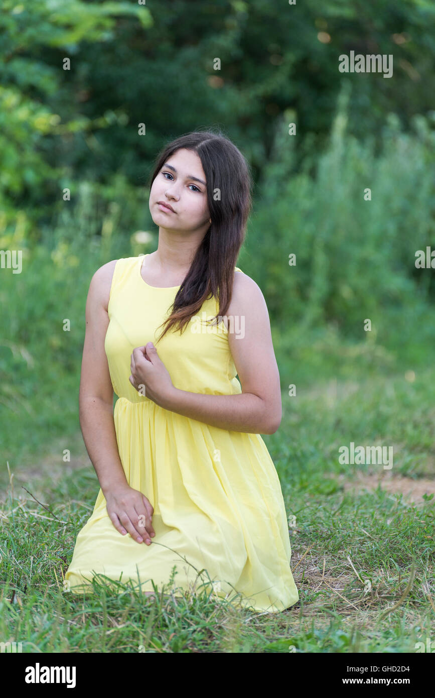 The girl in yellow dress sitting on grass Stock Photo - Alamy