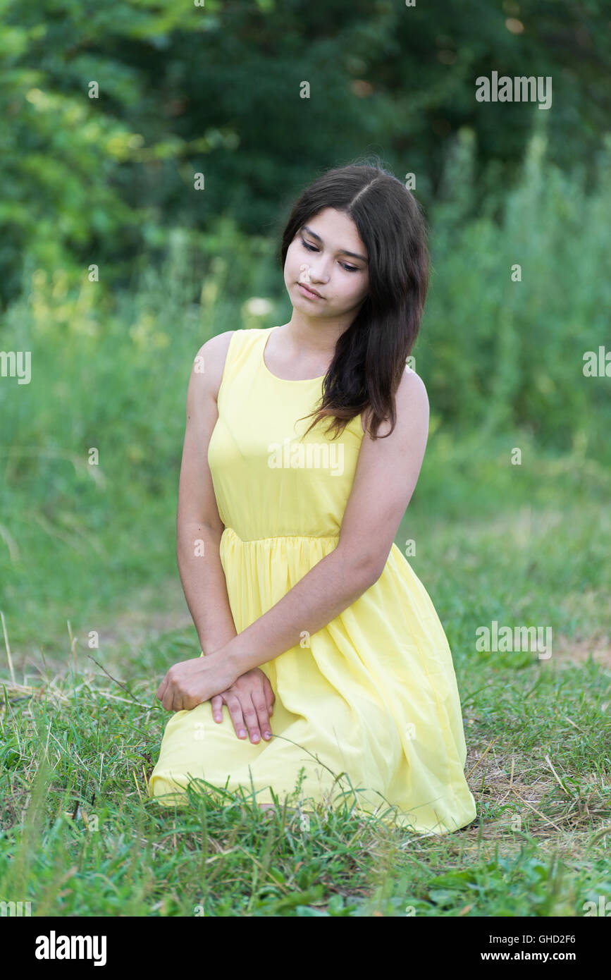 The girl in yellow dress sitting on grass Stock Photo - Alamy
