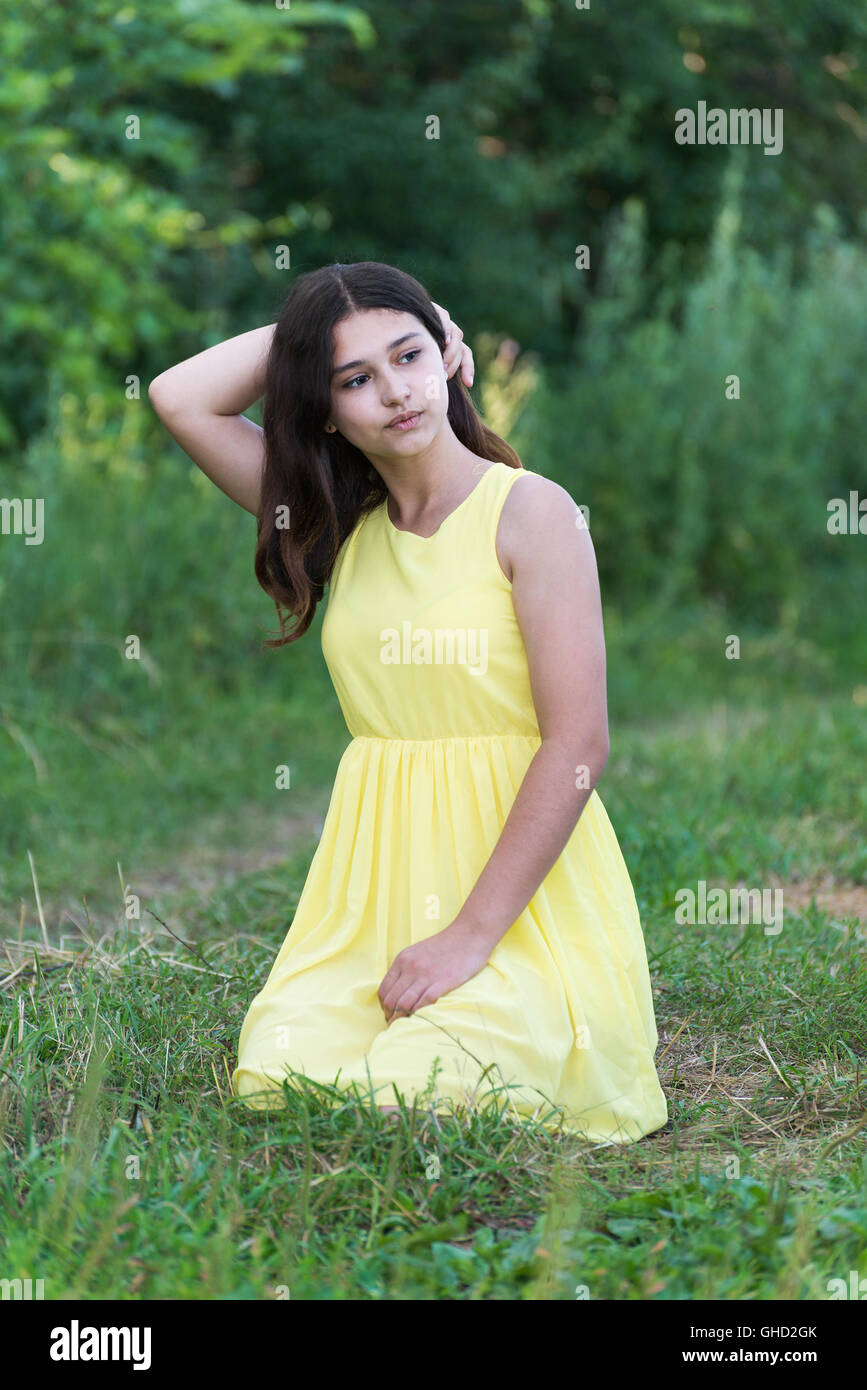 The girl in yellow dress sitting on grass Stock Photo - Alamy