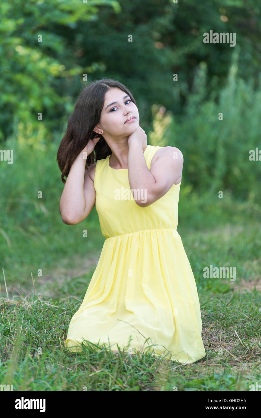 The girl in yellow dress sitting on grass Stock Photo - Alamy