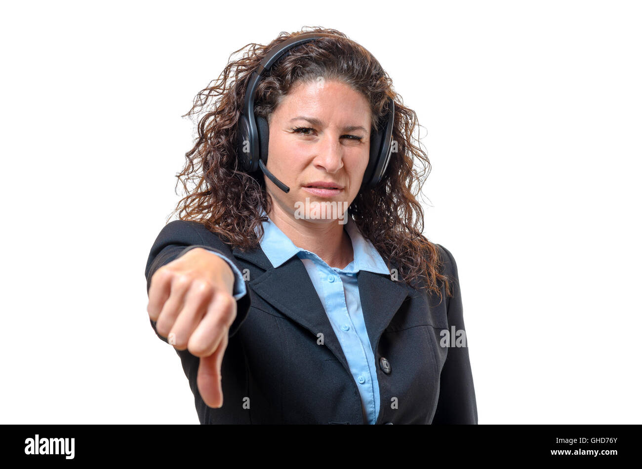 Young businesswoman wearing a headset signalling her disgust and disapproval with a thumbs down gesture, isolated on white Stock Photo