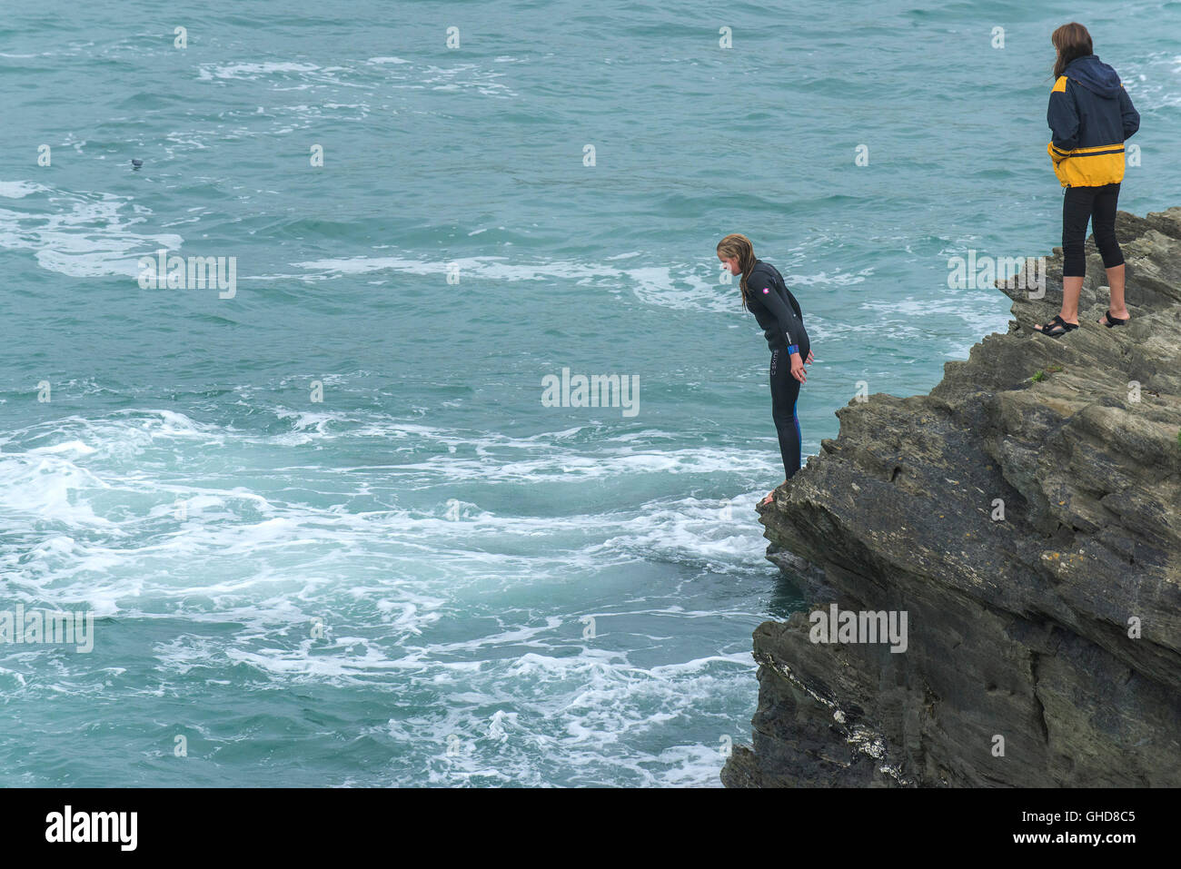 A young girl tombstoning off cliffs on Towan Headland in Newquay, Cornwall. Stock Photo