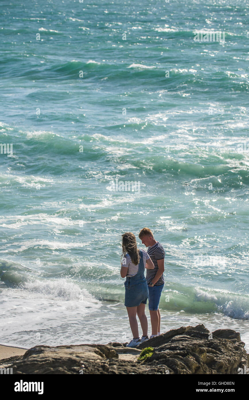 Holidaymakers stand on the rocks on Towan Headland in Newquay, Cornwall. Stock Photo