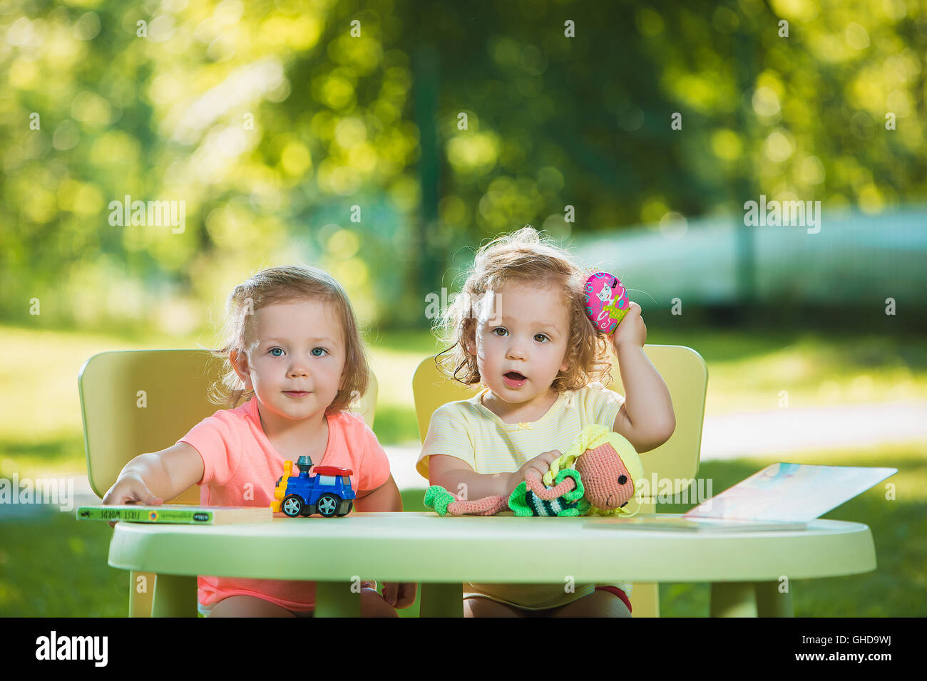 The two little baby girls playing toys in sand Stock Photo - Alamy