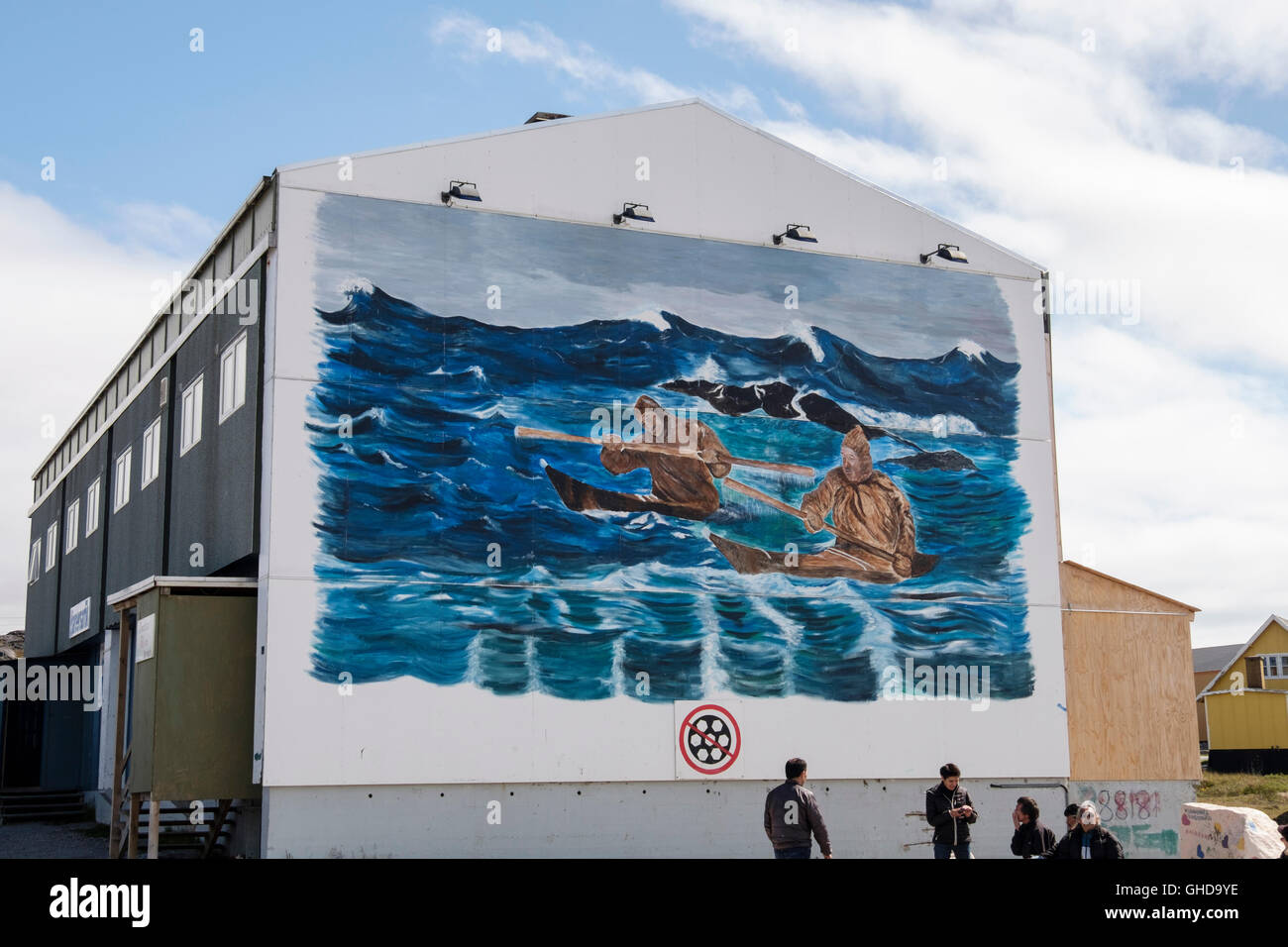 Mural depicting Inuit life kayaking scene painted on outside wall of a building where locals gather in Paamiut Greenland Stock Photo