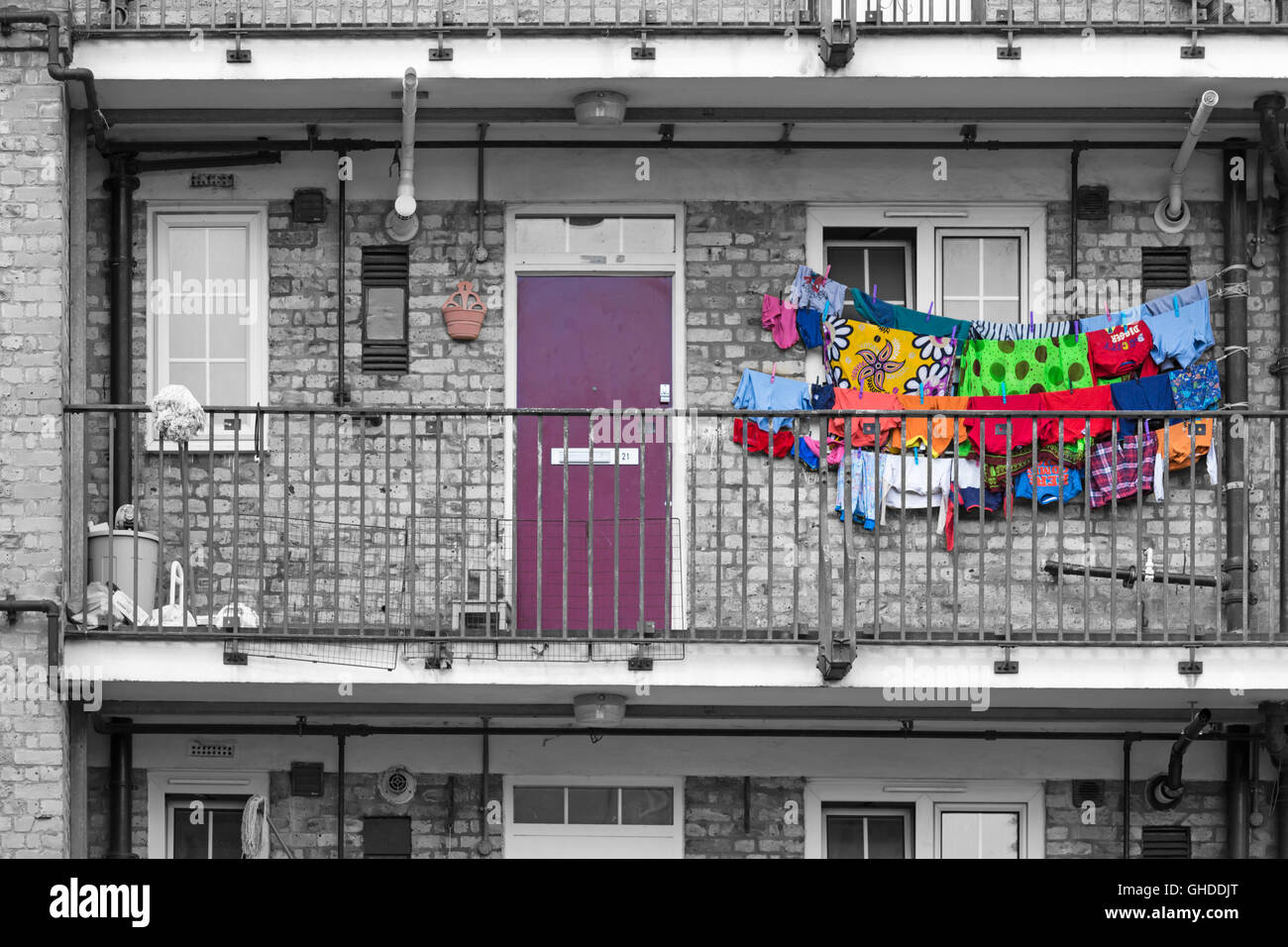 Colourful washing hanging outside flat in Bethnal Green area, city of London UK in July in monochrome with selective colour colouring, colour popping Stock Photo