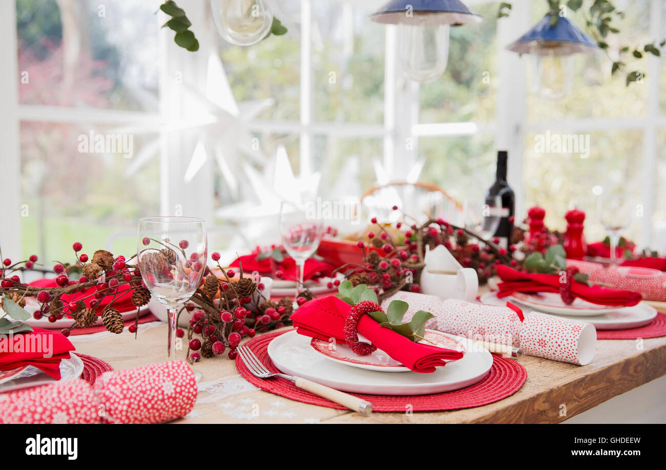 Placesettings and Christmas decorations on dining table Stock Photo