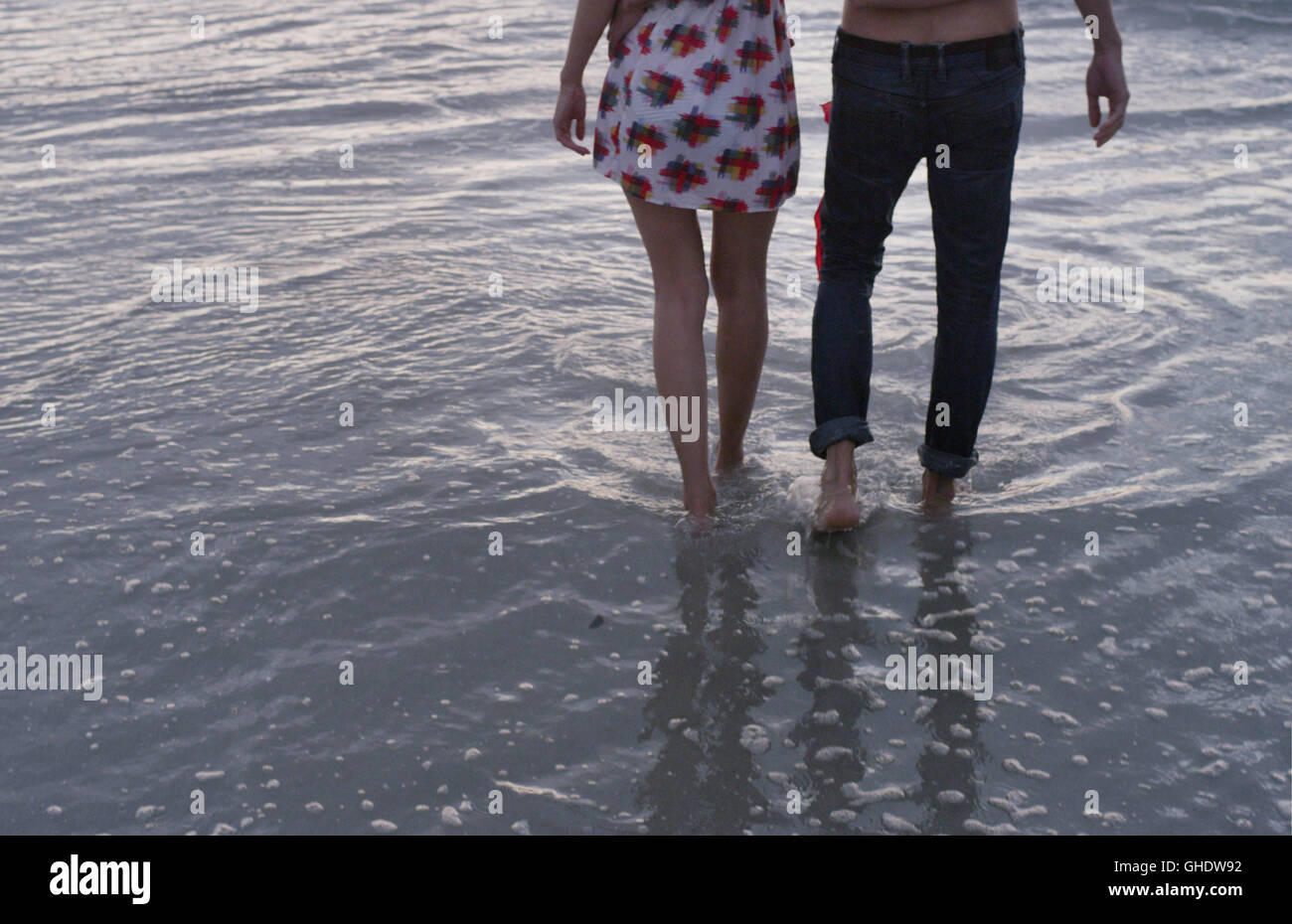 Young couple walking in ocean surf Stock Photo