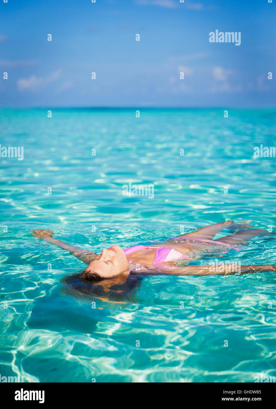 Serene woman floating in tropical ocean Stock Photo