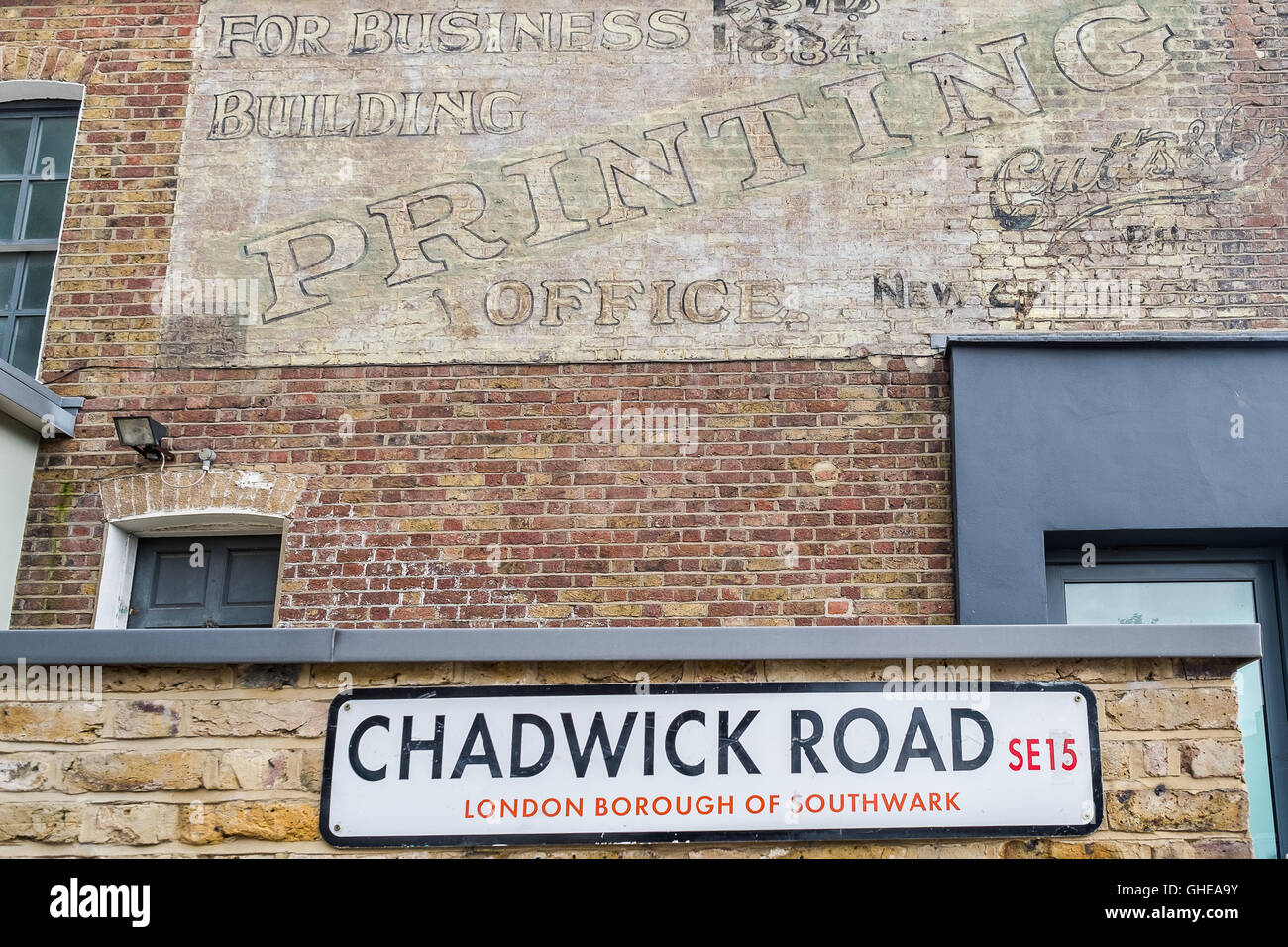 Chadwick Road, SE15 street sign on wall below an old Printing business sign, Peckham, South East London, England, UK Stock Photo