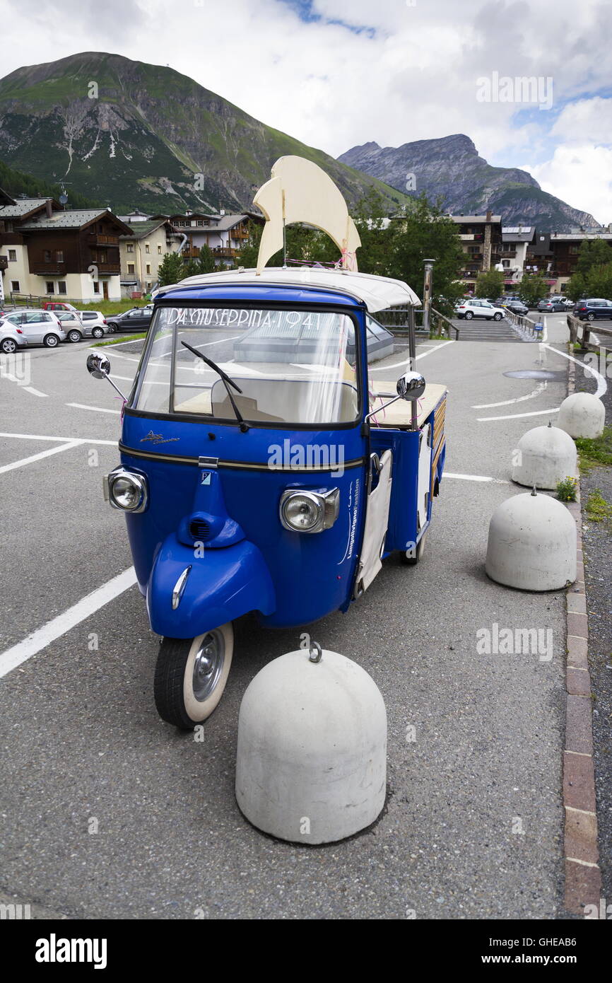 Limited edition model of three-wheeled vehicle Piaggio Ape Calessino stands on street on 1 August 2016 in Livigno, Italy. Stock Photo