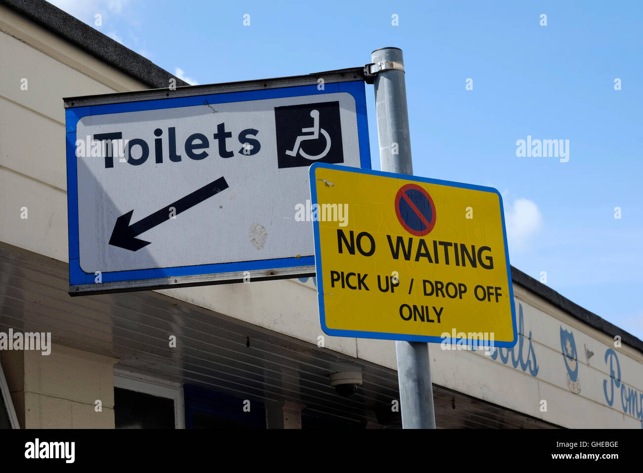 two information signs oddly placed together toilets pick up and drop