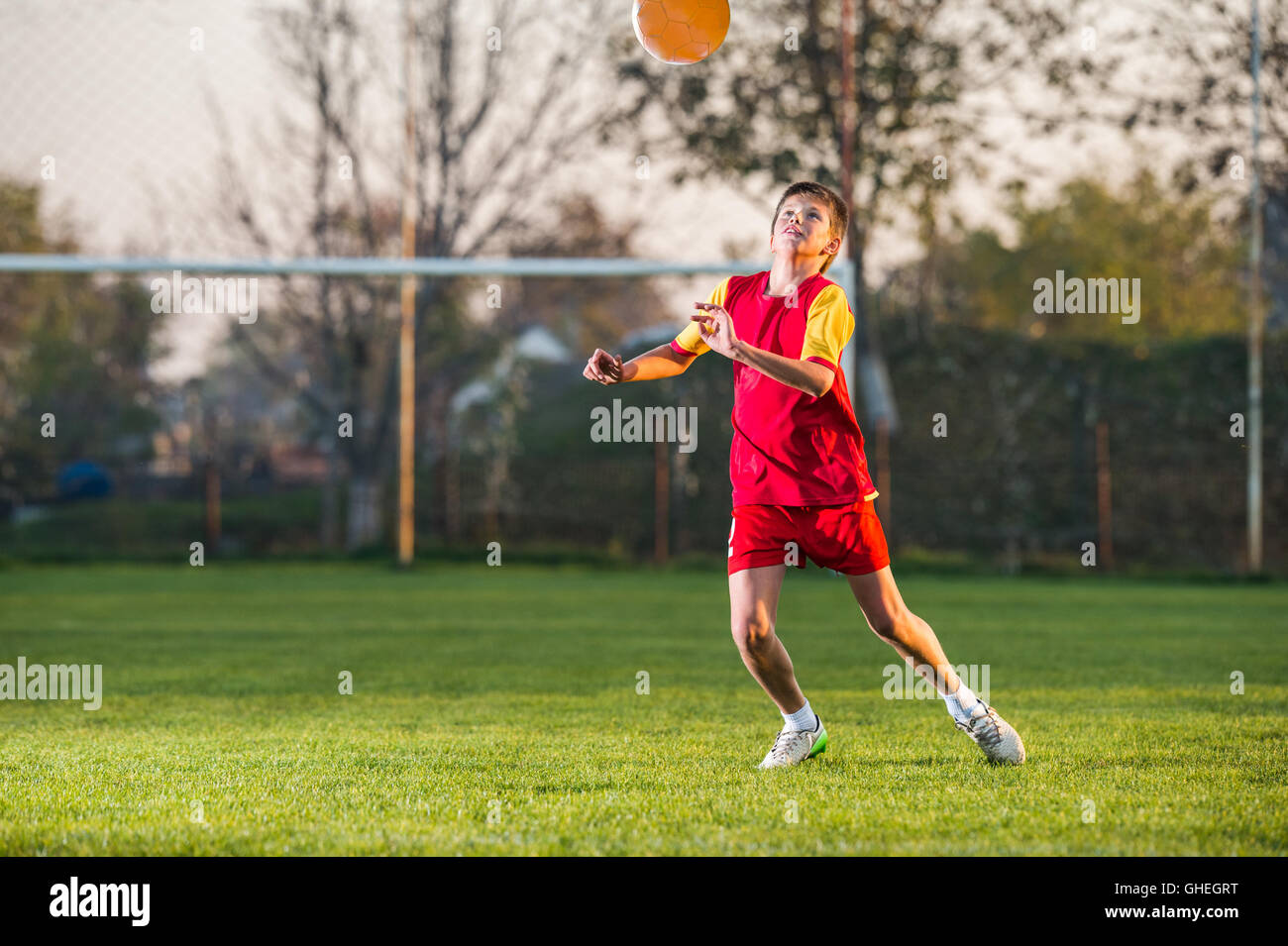 Child playing football on a soccer field Stock Photo - Alamy