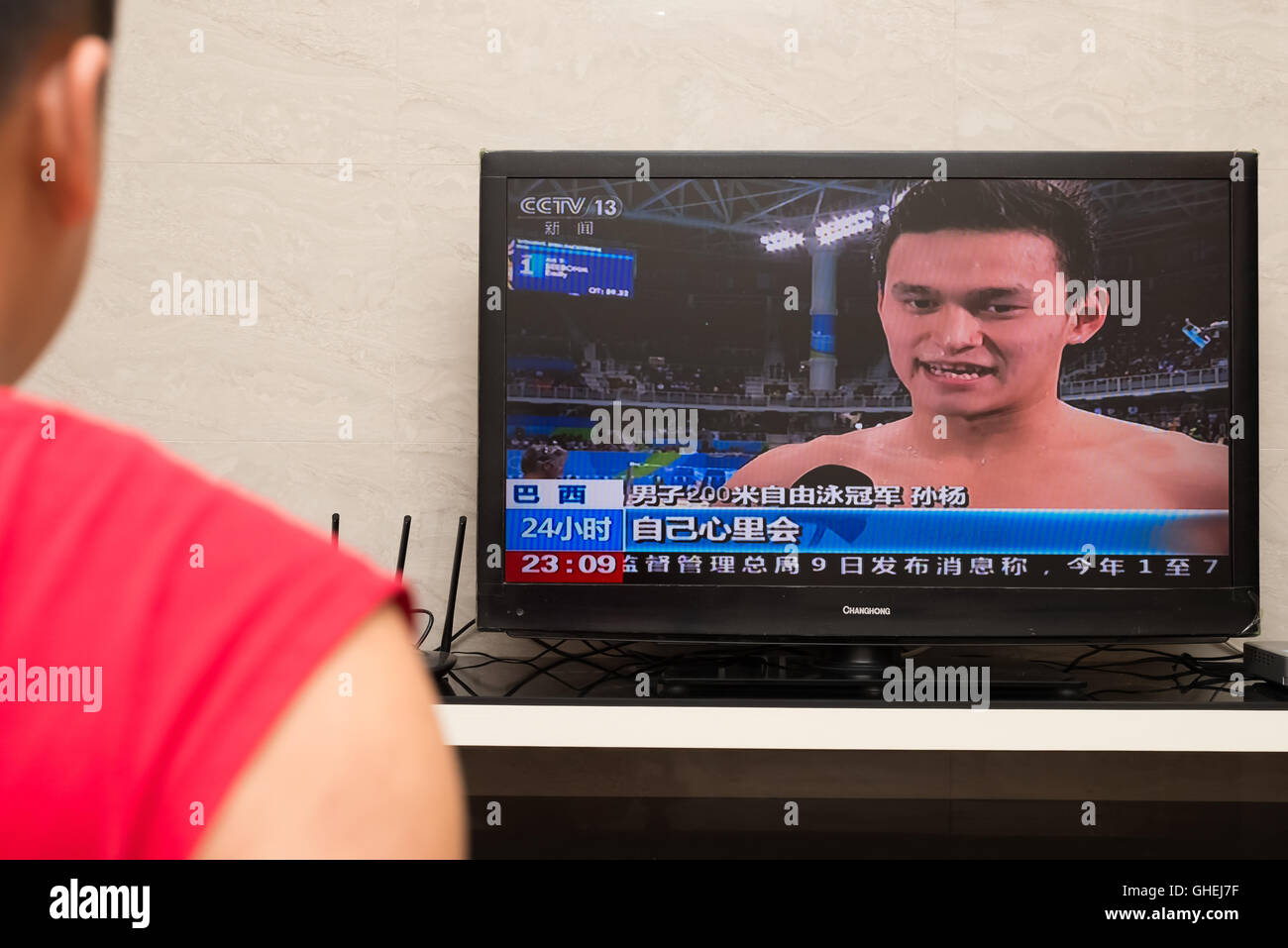 ZHONGSHAN CHINA-August 9:a Chinese watching TV broadcasting the interview of SunYang who wins the 200-meter freestyle swimming m Stock Photo