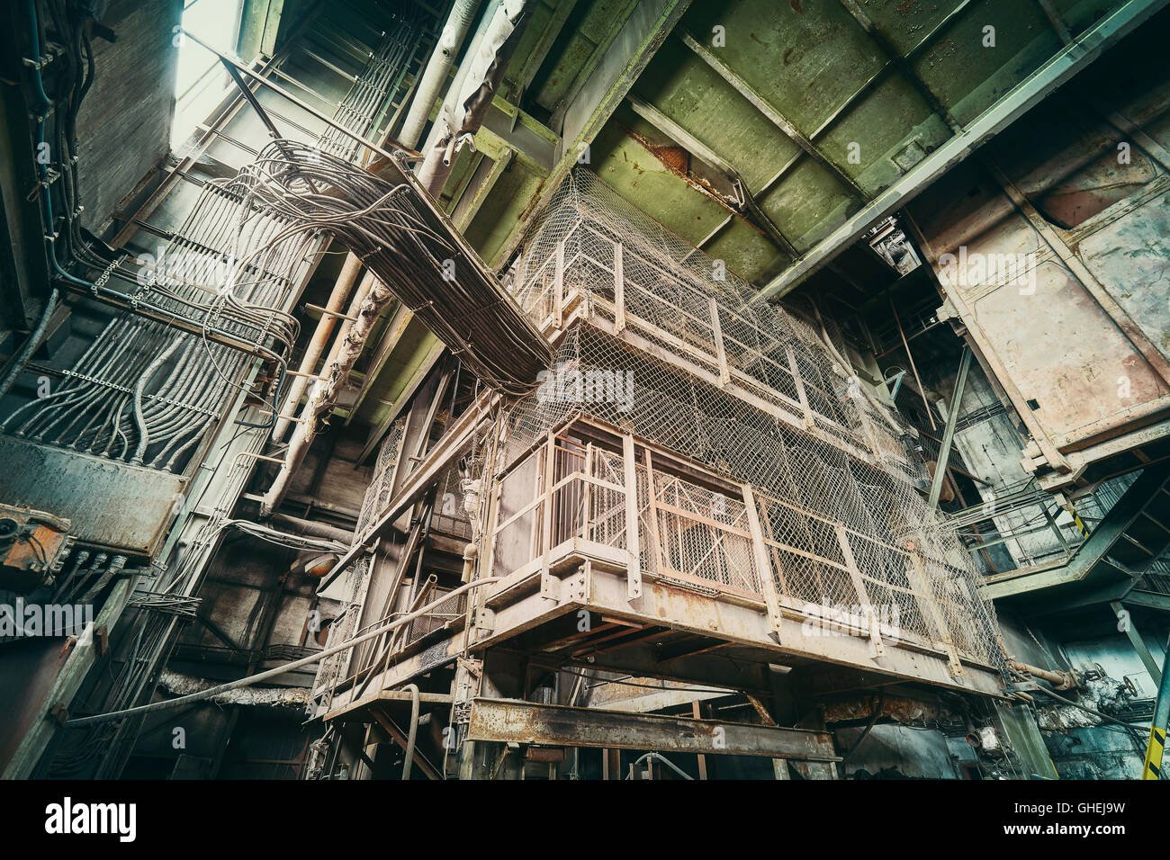 Vintage toned abandoned industrial interior, lapse of time and deterioration concept. Stock Photo