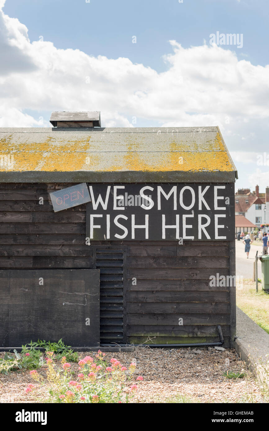 A We Smoke fish here sign on a fish smokery or smoking house shed on