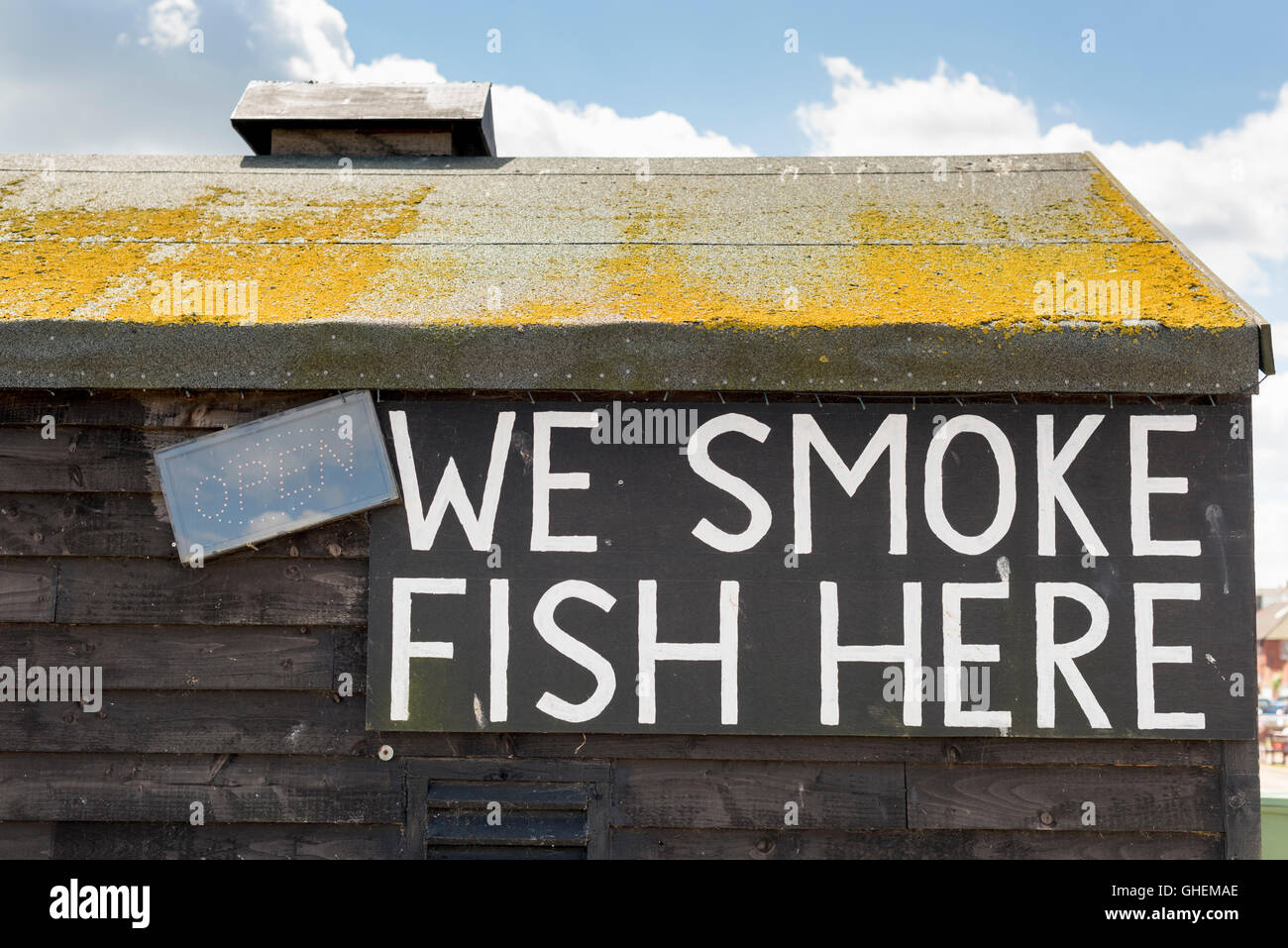 A We Smoke fish here sign on a fish smokery or smoking house shed on