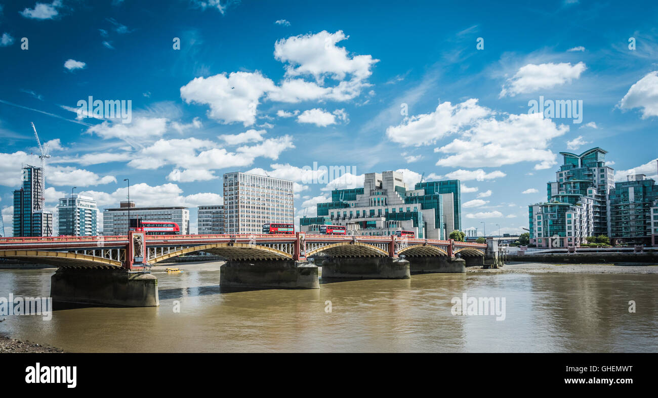 Mi6 Headquarters Building at Vauxhall Cross with Vauxhall Bridge and London Routemaster buses in the foreground Stock Photo
