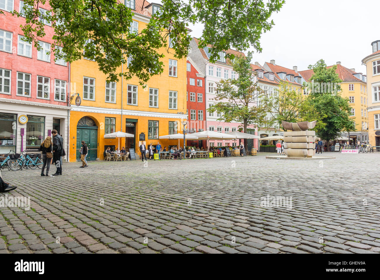 People walking around at the Grabrodretorv, a public square with colourful houses and restaurants in the centre of Copenhagen Stock Photo