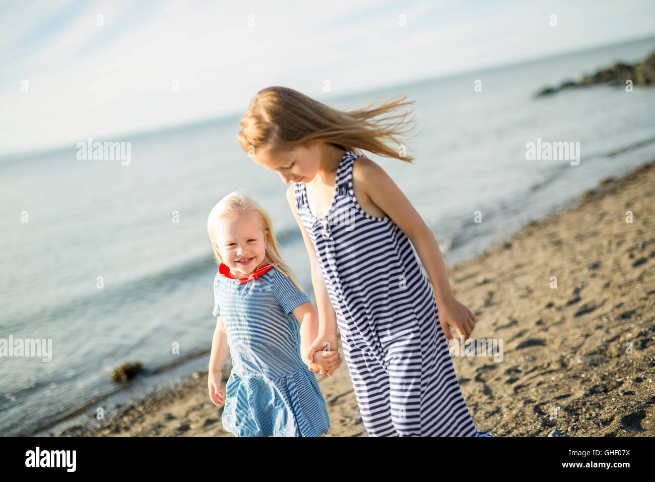 sisters at the beach on sunset Stock Photo - Alamy
