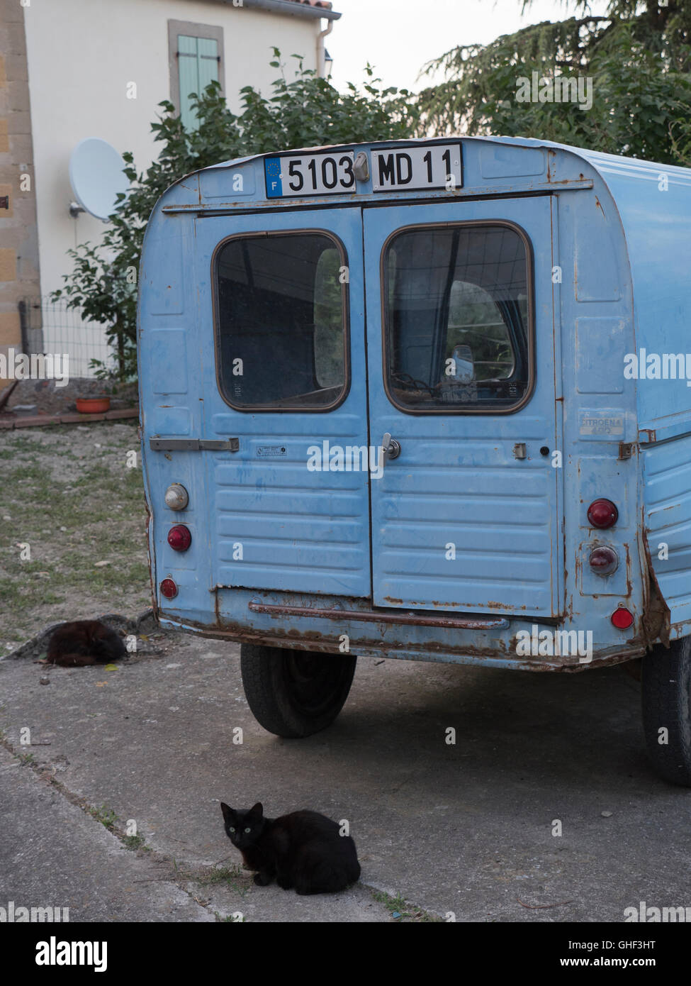 Typical French rural scene of old Citroen 2CV van with 2 black cats Stock Photo