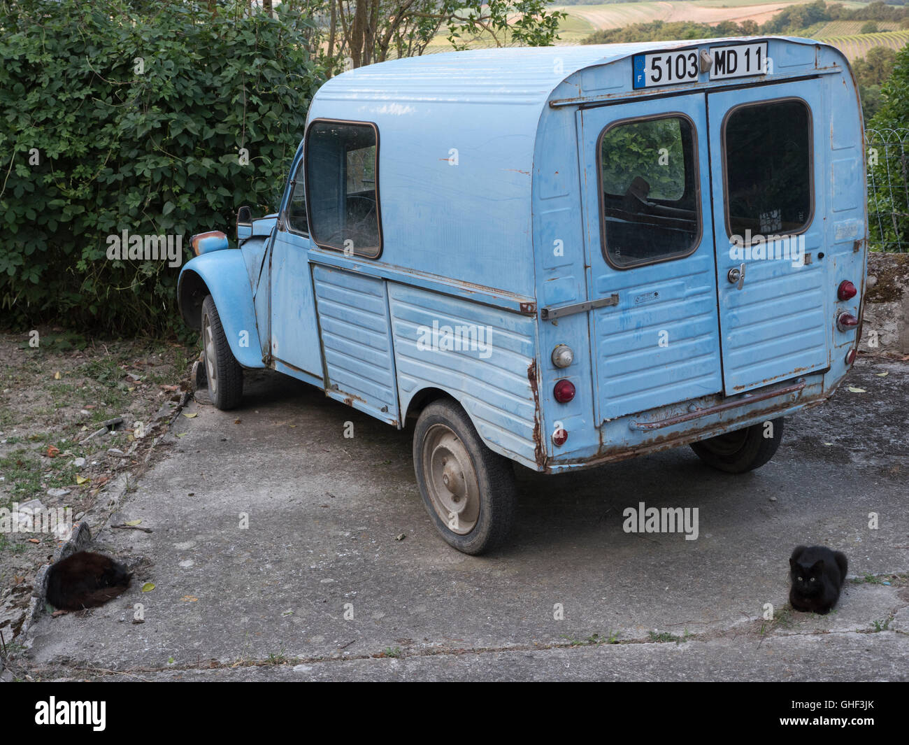 Typical French rural scene of old Citroen 2CV van with 2 black cats Stock Photo