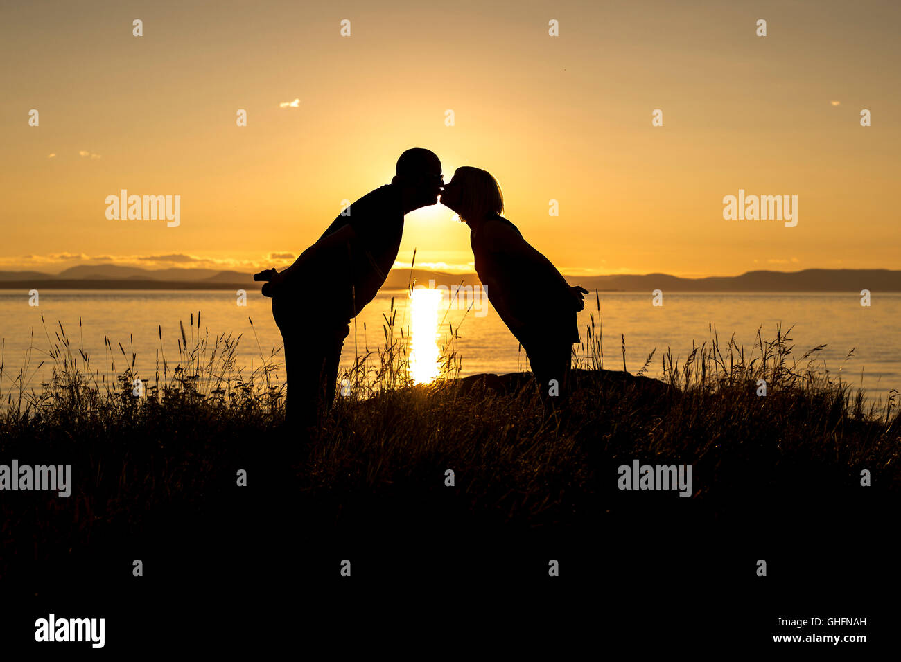 Silhouettes of romantic couple on tropical beach at sunset Stock Photo ...