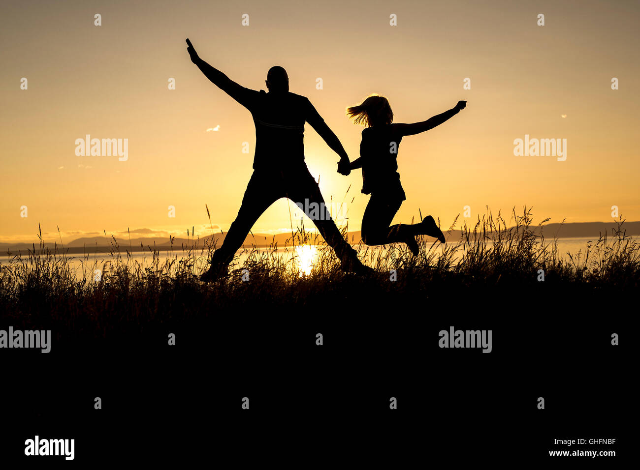 Silhouettes of romantic couple on tropical beach at sunset Stock Photo ...