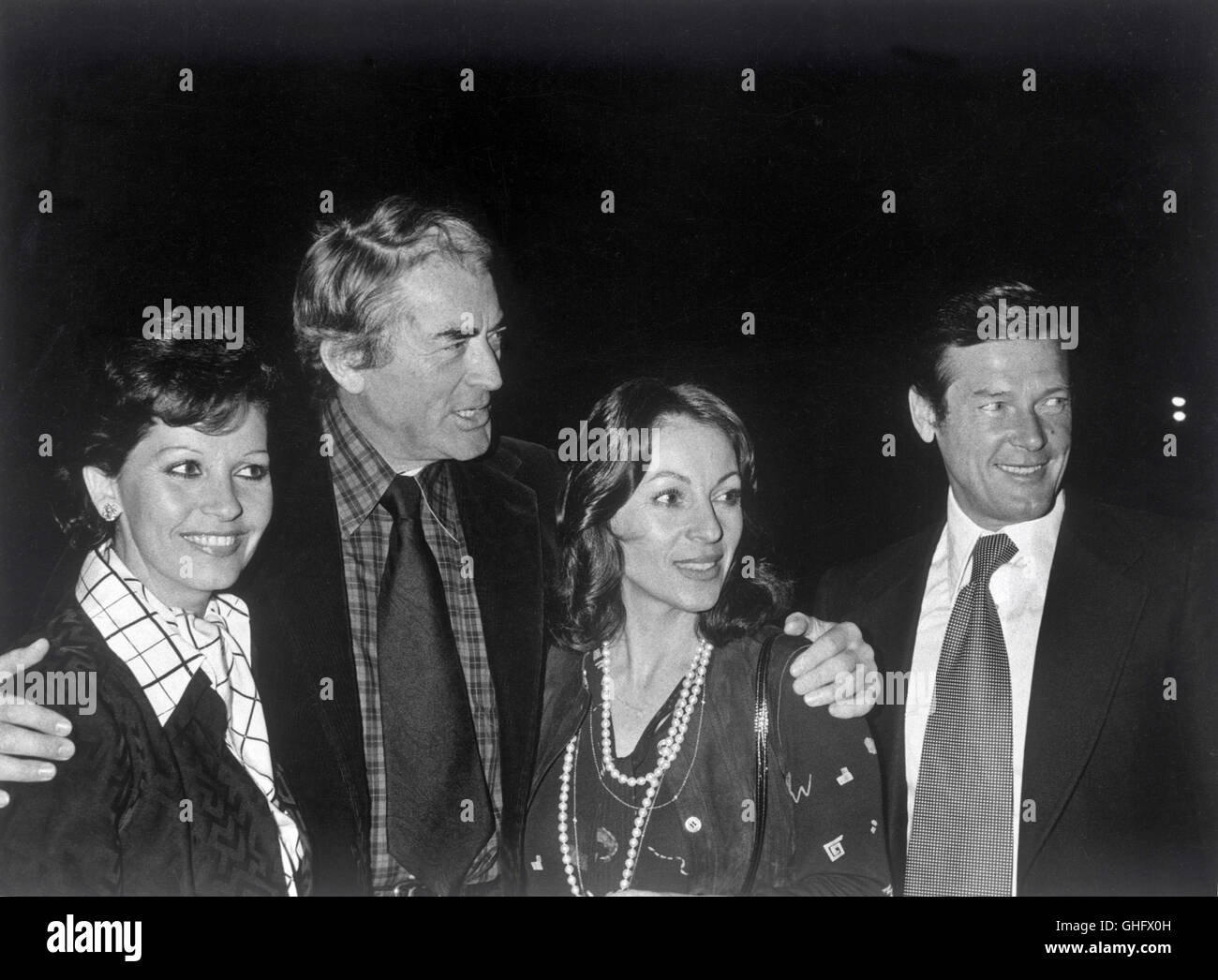 Film Stars GREGORY PECK and ROGER MOORE with wives (1980) Stock Photo